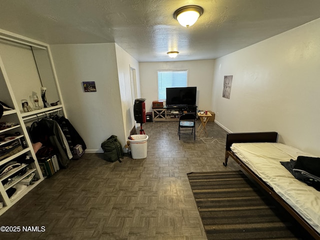 bedroom with a textured ceiling and baseboards