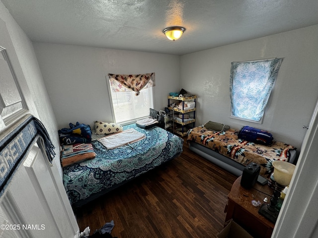 bedroom with a textured ceiling and wood finished floors