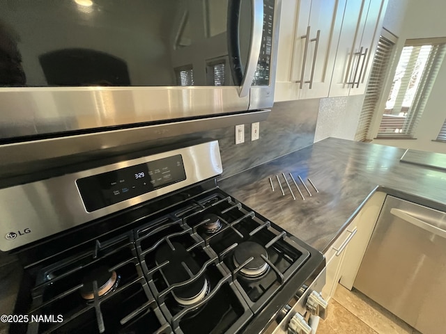 kitchen featuring stainless steel counters, appliances with stainless steel finishes, and white cabinetry