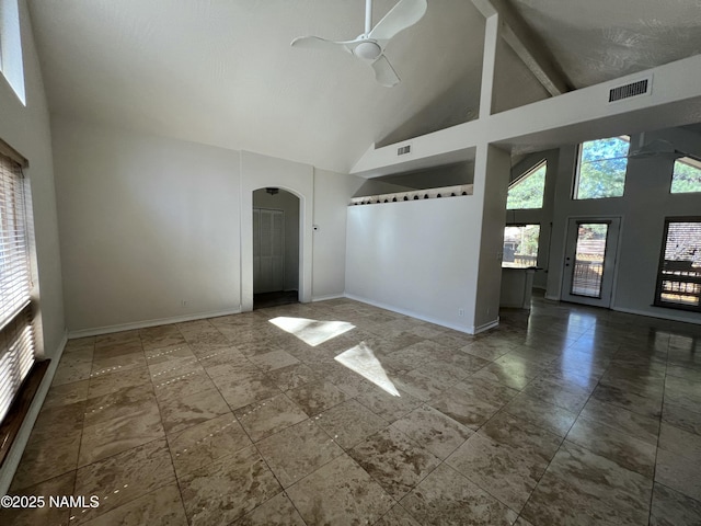 unfurnished living room with arched walkways, ceiling fan, baseboards, visible vents, and high vaulted ceiling