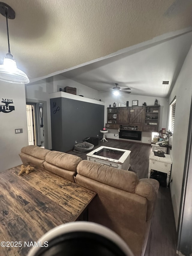 255 S Beech Dr, Flagstaff, AZ 86004 - living room featuring a textured ceiling, vaulted ceiling, visible vents, wood finished floors, and ceiling fan