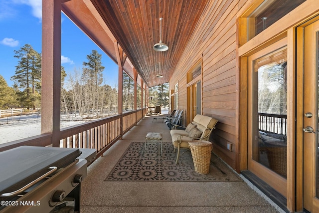 wooden deck featuring area for grilling and a porch