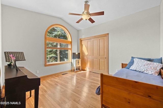 bedroom with visible vents, wood finished floors, baseboards, ceiling fan, and vaulted ceiling