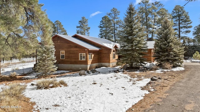 view of snowy exterior with fence