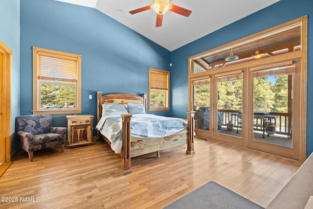 bedroom featuring lofted ceiling, wood finished floors, a ceiling fan, and access to outside