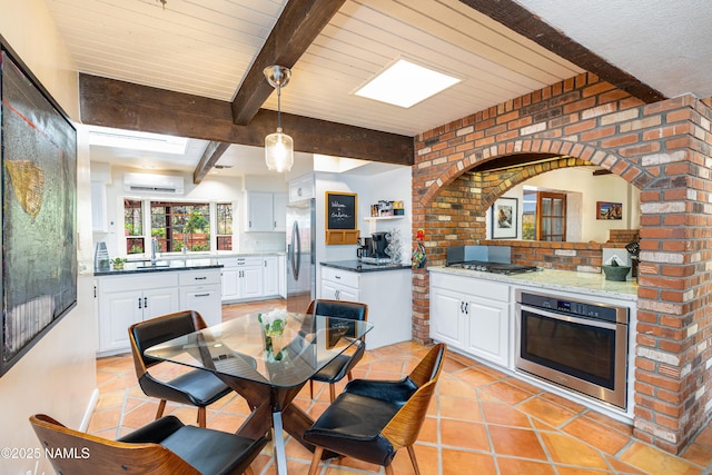 1125 Trails End Dr, Sedona, AZ 86336 - dining space featuring beamed ceiling, a wall mounted AC, and light tile patterned flooring