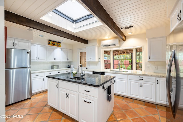 1125 Trails End Dr, Sedona, AZ 86336 - kitchen featuring freestanding refrigerator, a sink, a skylight, a wall mounted AC, and wooden ceiling with exposed beams