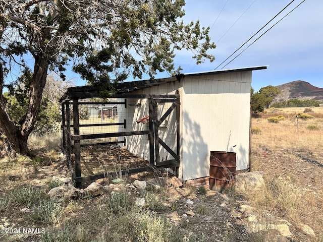 view of home's exterior with an outbuilding and a mountain view