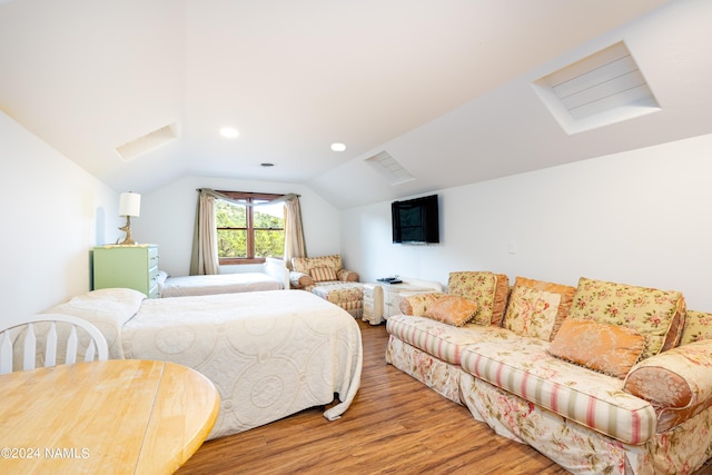 bedroom with hardwood / wood-style floors and lofted ceiling