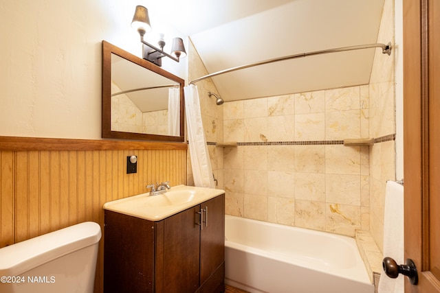 full bathroom featuring toilet, vanity, shower / tub combo, and wooden walls