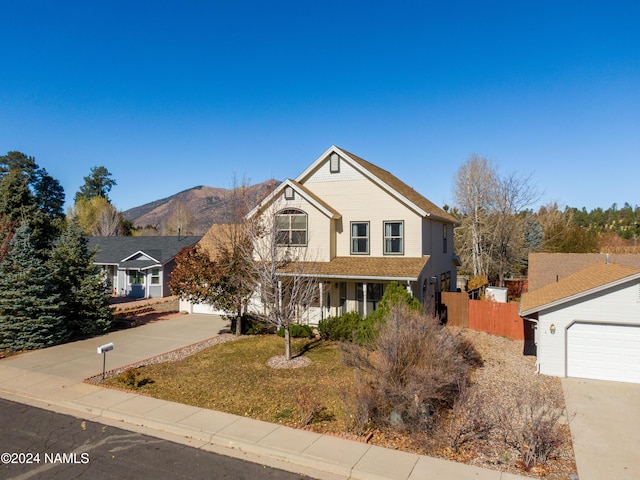 view of front of house with a mountain view, a front yard, and a garage