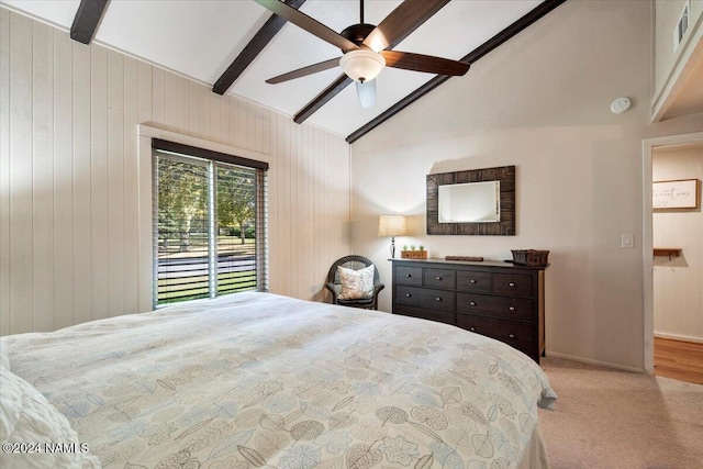 carpeted bedroom featuring lofted ceiling with beams, ceiling fan, and wood walls