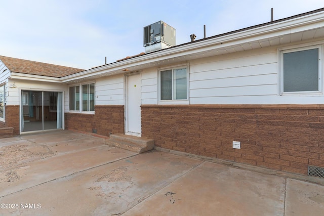 rear view of property featuring central AC unit and a patio area