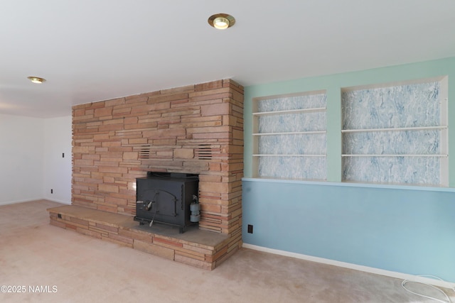 unfurnished living room with carpet floors and a wood stove