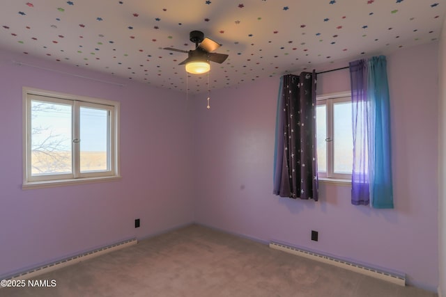 spare room featuring a healthy amount of sunlight, baseboard heating, and carpet floors