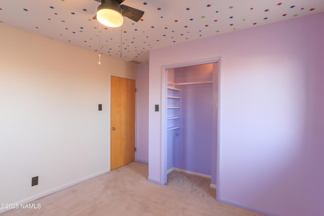 unfurnished bedroom featuring light carpet, a closet, and ceiling fan