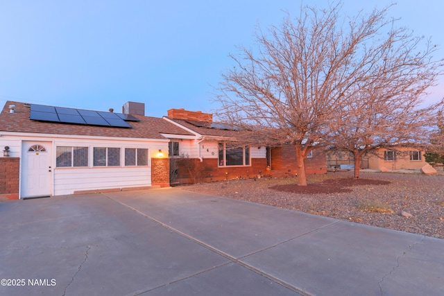 view of front of house featuring a garage and solar panels