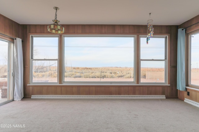 interior space featuring baseboard heating, wooden walls, and carpet