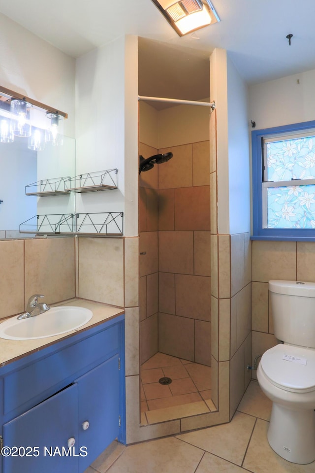 bathroom featuring tiled shower, tile patterned floors, and tile walls