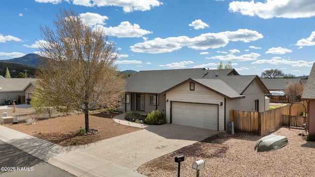 905 Hereford Dr, Williams, AZ 86046 - view of front of house with fence, an attached garage, driveway, a mountain view, and roof with shingles