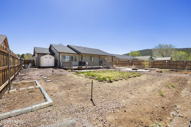 905 Hereford Dr, Williams, AZ 86046 - rear view of house featuring a storage shed, a fenced backyard, a deck, and an outdoor structure
