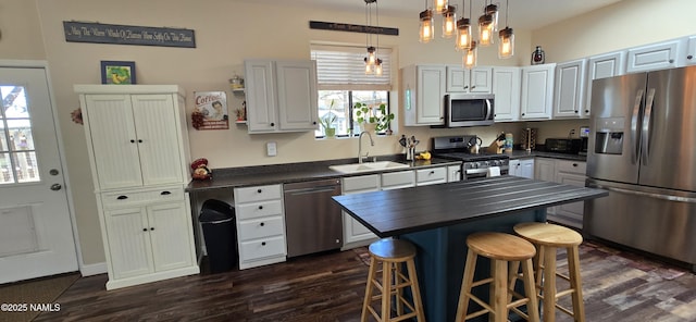1111 W Sheridan Ave, Williams, AZ 86046 - kitchen with stainless steel appliances, a sink, dark wood-style floors, a kitchen breakfast bar, and white cabinetry