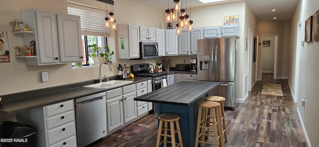 1111 W Sheridan Ave, Williams, AZ 86046 - kitchen featuring appliances with stainless steel finishes, a sink, dark countertops, dark wood-style floors, and recessed lighting