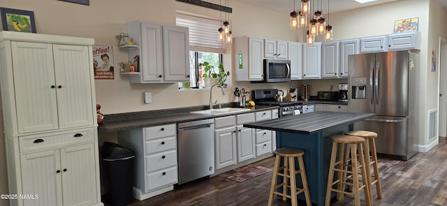 1111 W Sheridan Ave, Williams, AZ 86046 - kitchen with appliances with stainless steel finishes, a sink, dark wood-type flooring, a breakfast bar area, and a kitchen island
