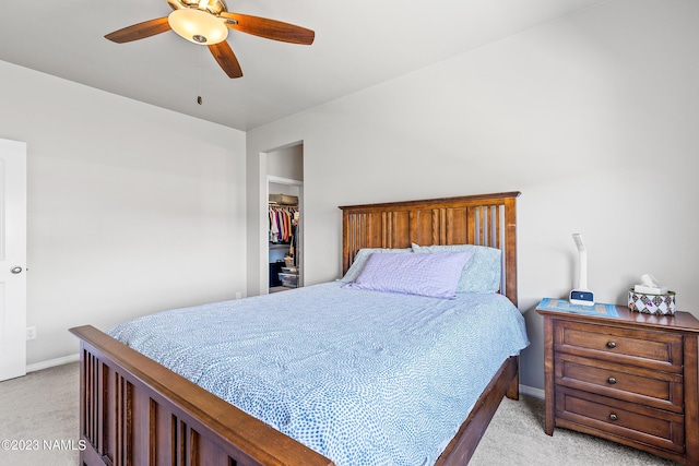 carpeted bedroom featuring ceiling fan, a closet, and a walk in closet