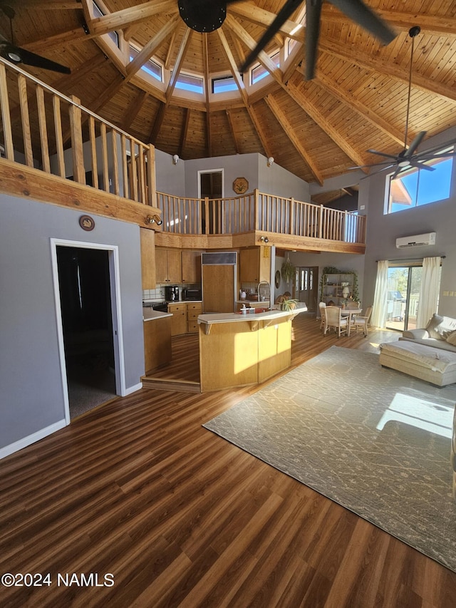 unfurnished living room with a towering ceiling, beamed ceiling, hardwood / wood-style floors, wooden ceiling, and ceiling fan