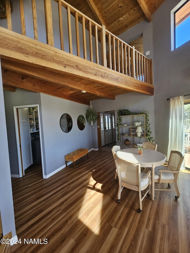 unfurnished dining area featuring wood ceiling, a high ceiling, beam ceiling, and dark wood-type flooring