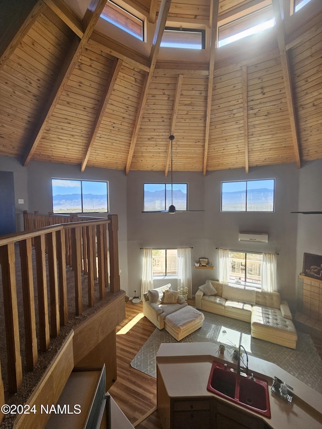 living room featuring an AC wall unit, a towering ceiling, wood ceiling, beamed ceiling, and sink