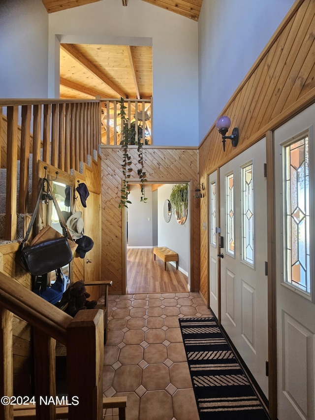 entrance foyer with wooden ceiling, lofted ceiling with beams, and wood walls