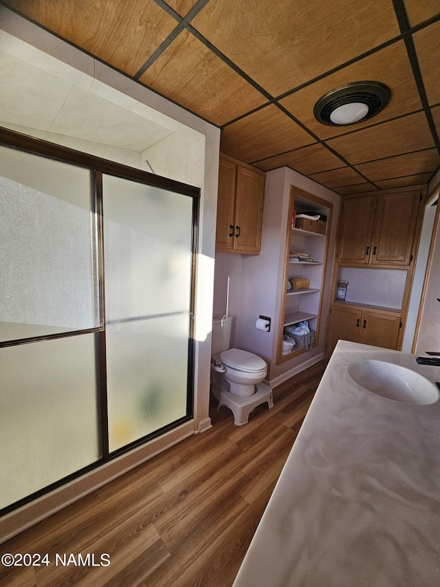 bathroom with wood-type flooring, sink, built in features, wooden ceiling, and a shower with shower door