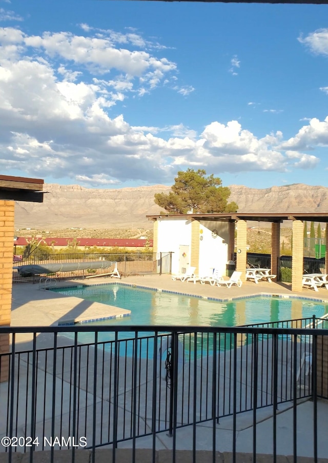 view of pool with a mountain view and a patio