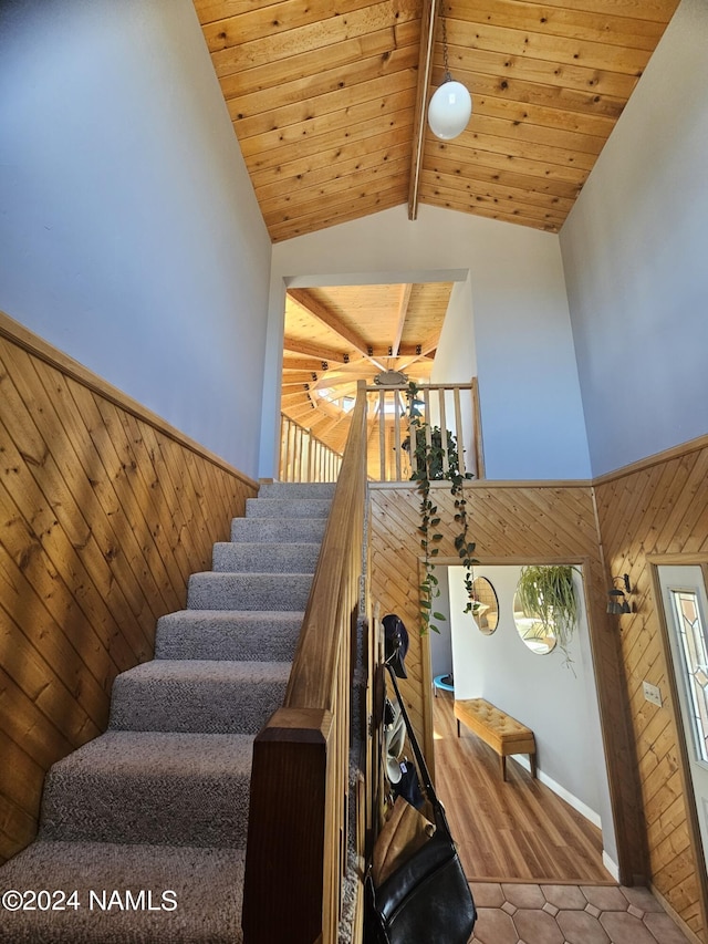 staircase with wood ceiling, tile patterned floors, and lofted ceiling with beams