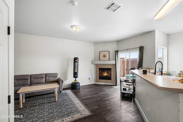9092 W Slate Mountain Trl, Bellemont, AZ 86015 - living room featuring dark wood-style flooring, baseboards, and a tile fireplace