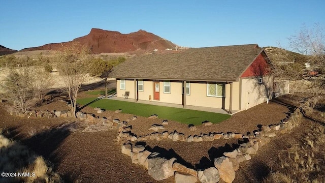 5197 Wade Ln, Flagstaff, AZ 86004 - rear view of house with a mountain view, a patio area, and a lawn