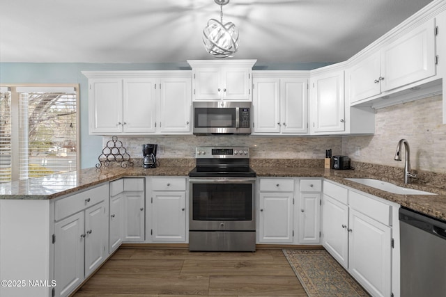 kitchen featuring appliances with stainless steel finishes, a sink, and white cabinetry