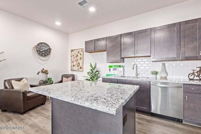 kitchen with dark brown cabinetry, a center island, tasteful backsplash, light hardwood / wood-style floors, and stainless steel dishwasher