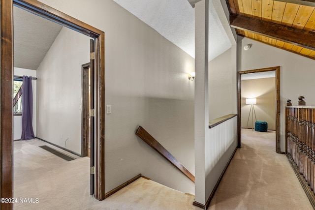 hallway with wood ceiling, light colored carpet, and vaulted ceiling with beams