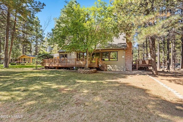 back of house featuring a wooden deck and a yard