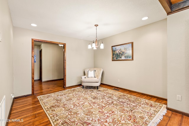 unfurnished room featuring hardwood / wood-style floors and a chandelier