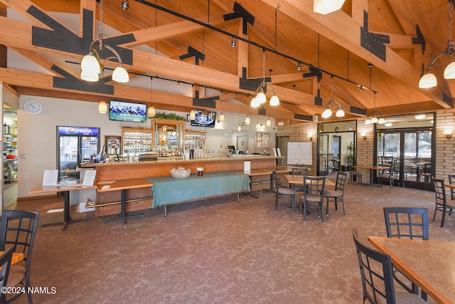 dining room featuring brick wall, carpet, track lighting, high vaulted ceiling, and beam ceiling