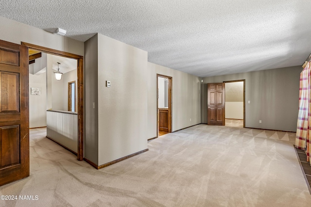 carpeted spare room with a textured ceiling