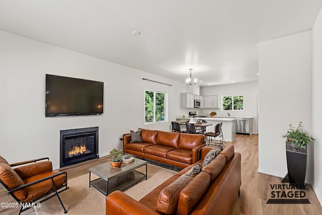5026 E Retreat Cir, Flagstaff, AZ 86004 - living area featuring light wood finished floors, a glass covered fireplace, and a chandelier