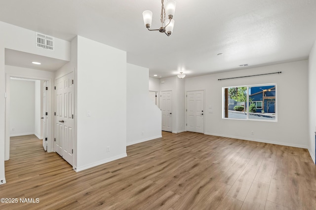5026 E Retreat Cir, Flagstaff, AZ 86004 - unfurnished living room featuring a chandelier, light wood-type flooring, and recessed lighting