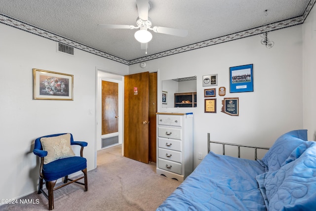 carpeted bedroom featuring ceiling fan and a textured ceiling