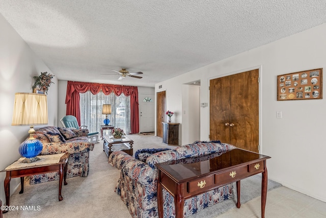 living room featuring ceiling fan and a textured ceiling