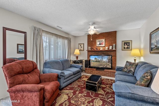 living room featuring ceiling fan, a fireplace, and a textured ceiling